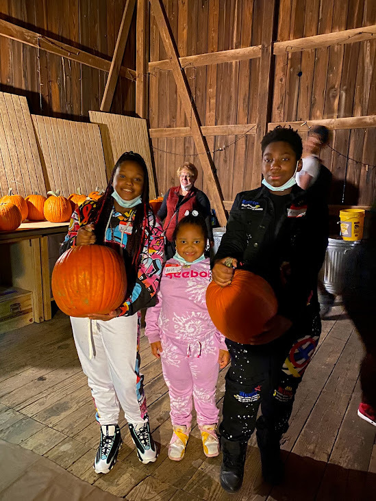 Students holding pumpkins they received at Tikkun Farm