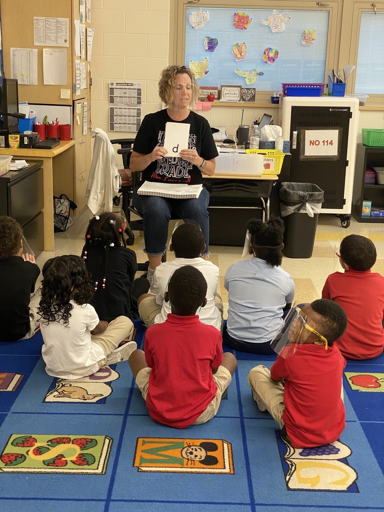 student learning new words with teacher in classroom